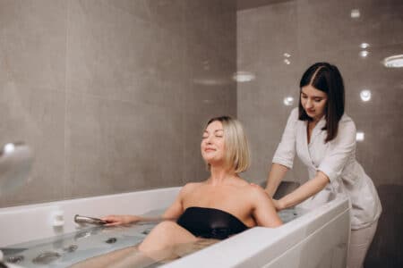 jeune femme pendant hydromassage dans salon beaute